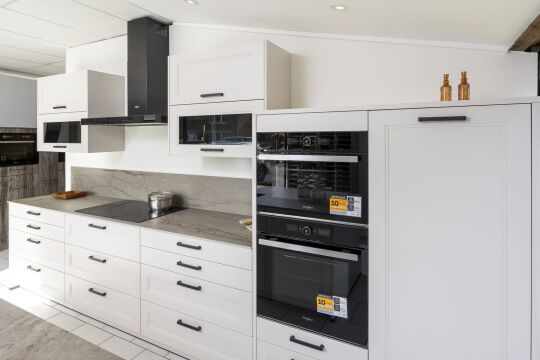 Witte keuken met eiland en zwarte afzuigkap