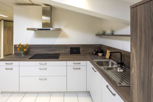 Witte hoekkeuken met donker werkblad en inox spoelbak